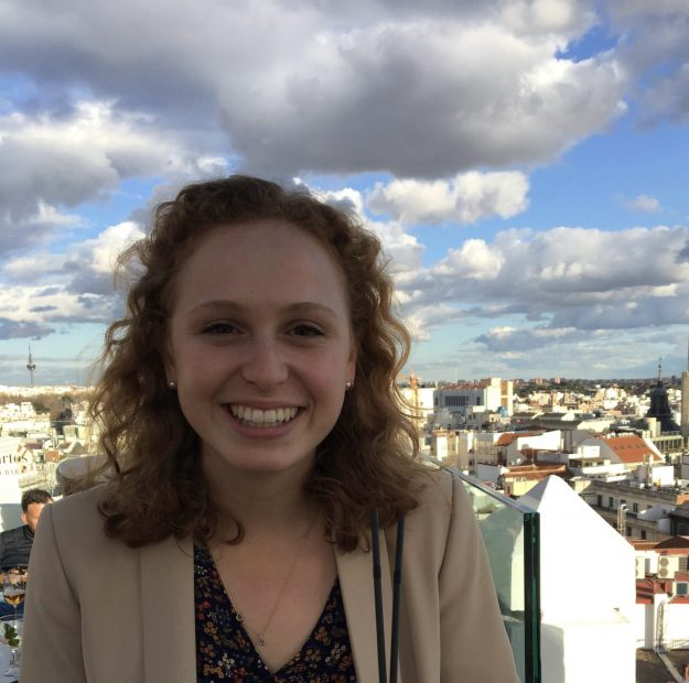 Headshot of white female against city landscape