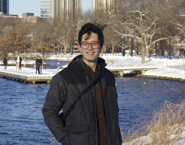 Aron Brenner standing in front of a river in the snow